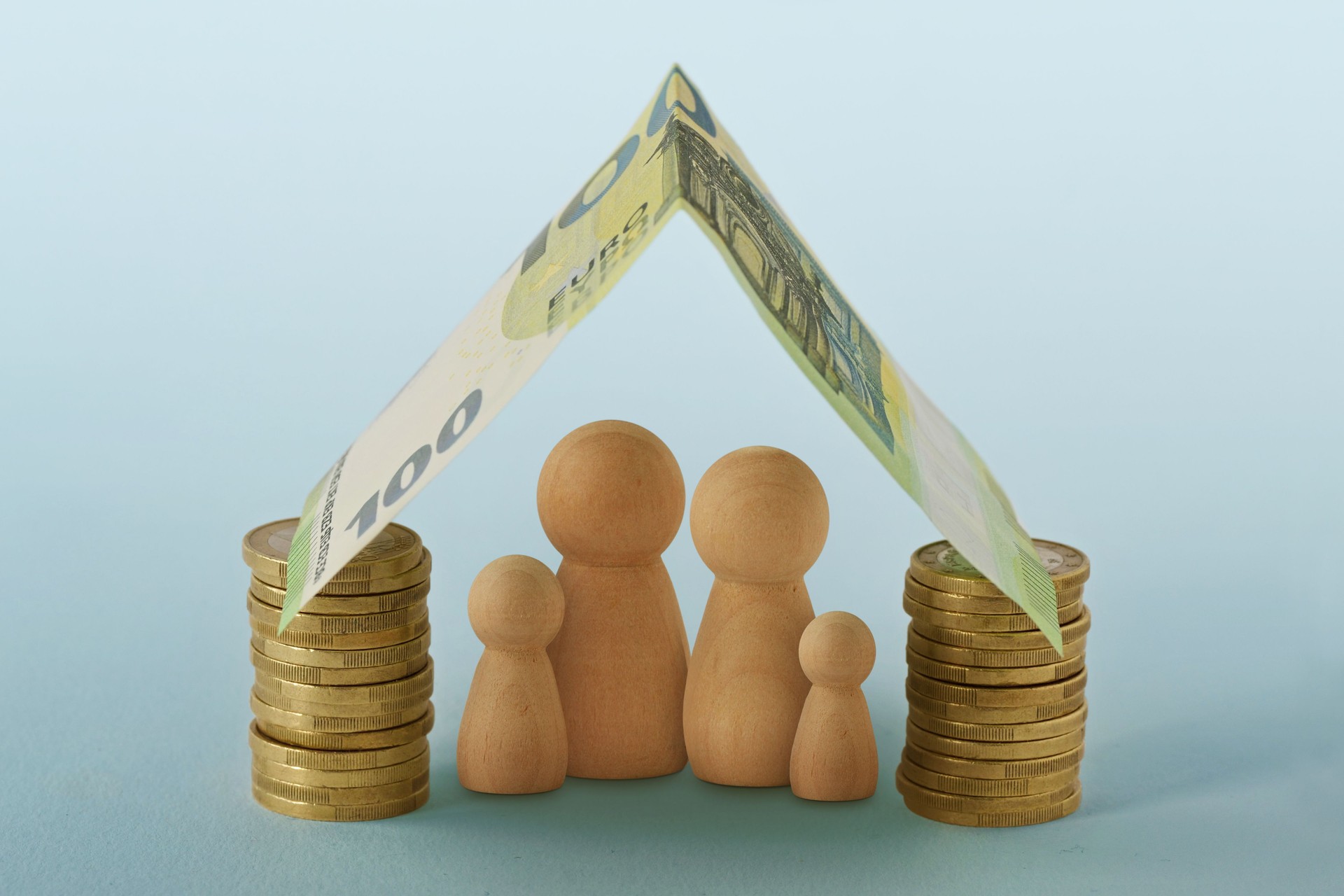 Family under house made of money - Concept of family, home and financial protection